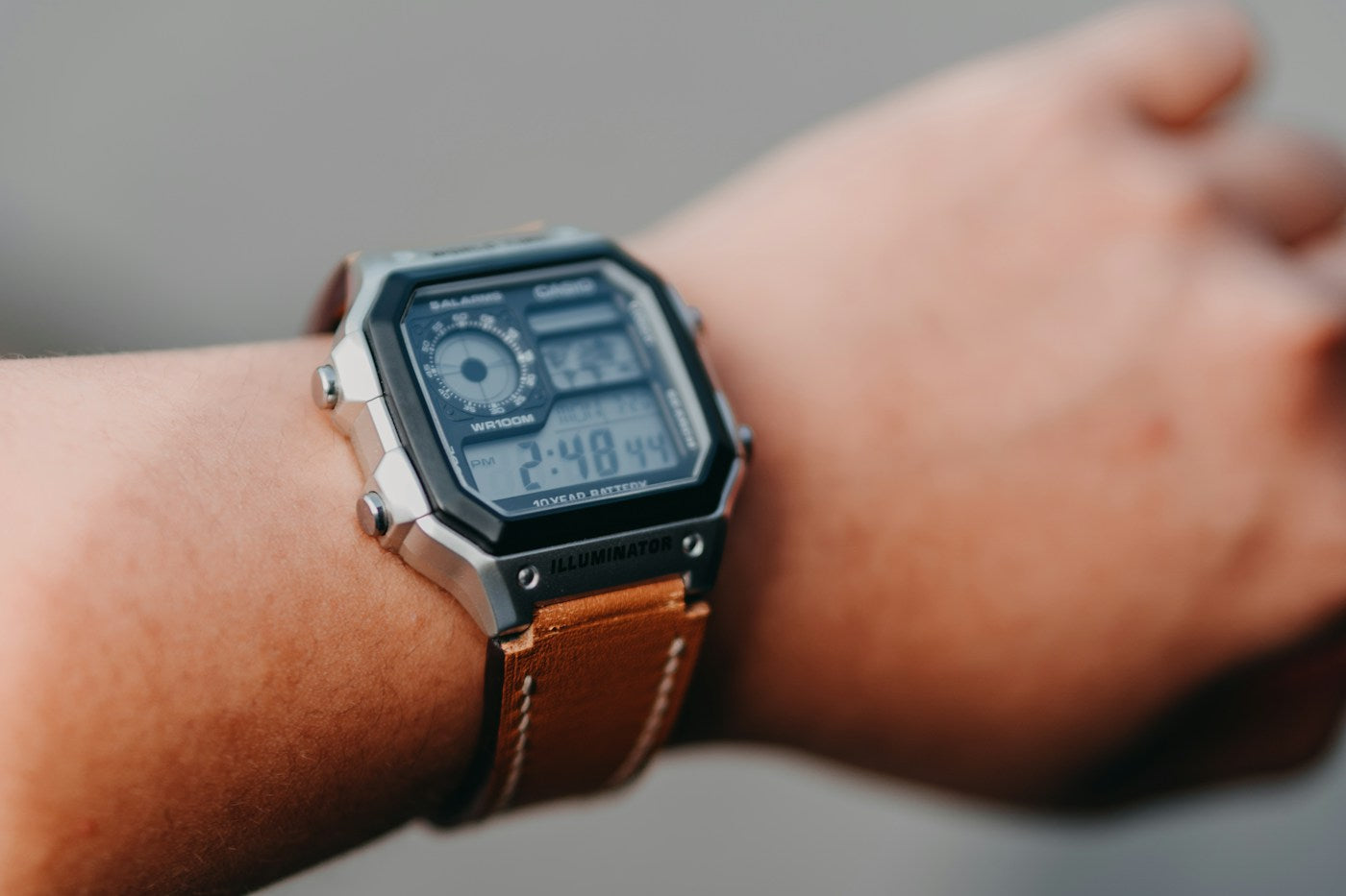 Digitale Casio-Uhr mit silberfarbenem Gehäuse am Handgelenk